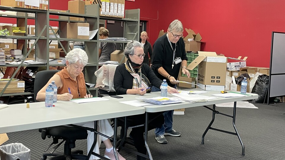 Des employés d’Élections Québec procèdent au recensement des votes dans un local électoral.
