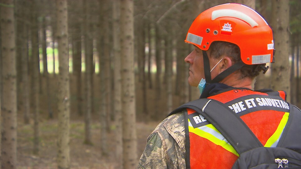 Un bénévole porte un casque et un dossard.