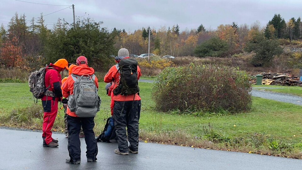 Trois personnes avec de l'équipement et des vêtements chauds se préparent à une battue.