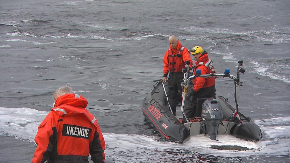 Deux hommes dans un bateau pneumatique sillonnent la rivière Mistassini.