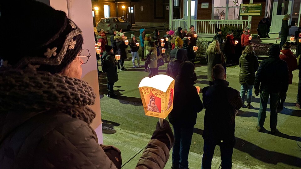 Des personnes qui portent des lampions sont debout devant la galerie les bureaux du Comité de solidarité Trois-Rivières.