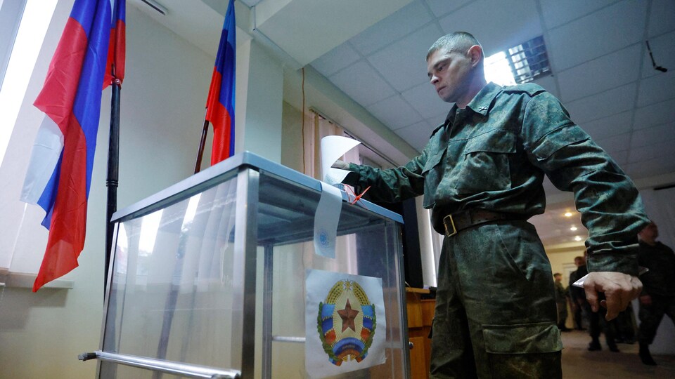Un soldat de la République populaire autoproclamée de Lougansk glisse son bulletin de vote dans l'urne. 
