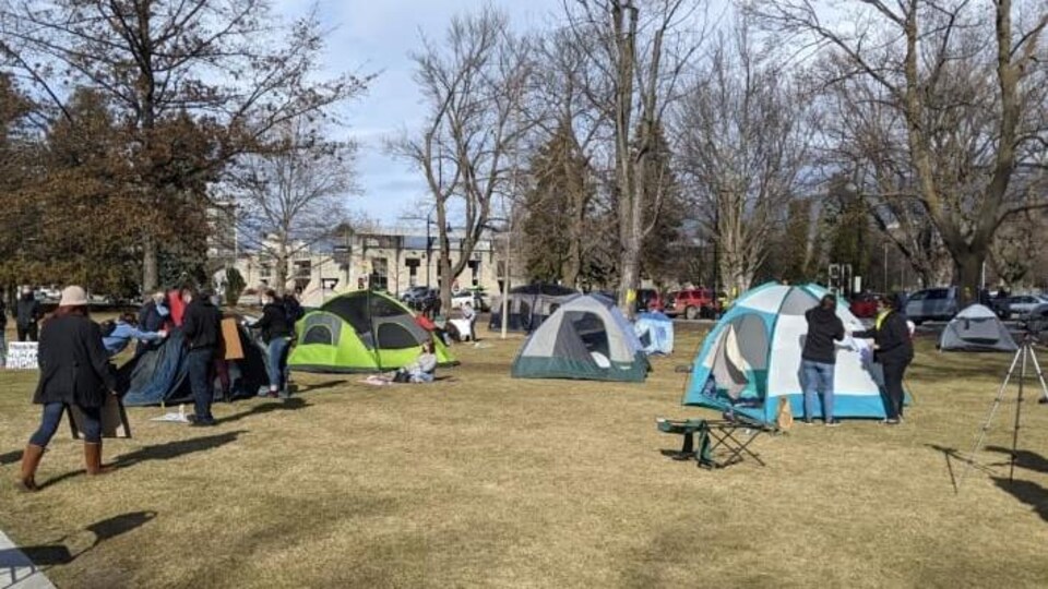 Des gens installent des tentes dans un parc.