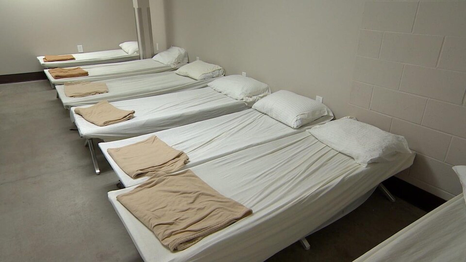 Une rangée de lits dans un dortoir d'un refuge.
