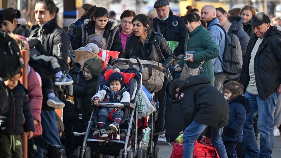 Dozens of people, mostly women and children, were walking on a pier.