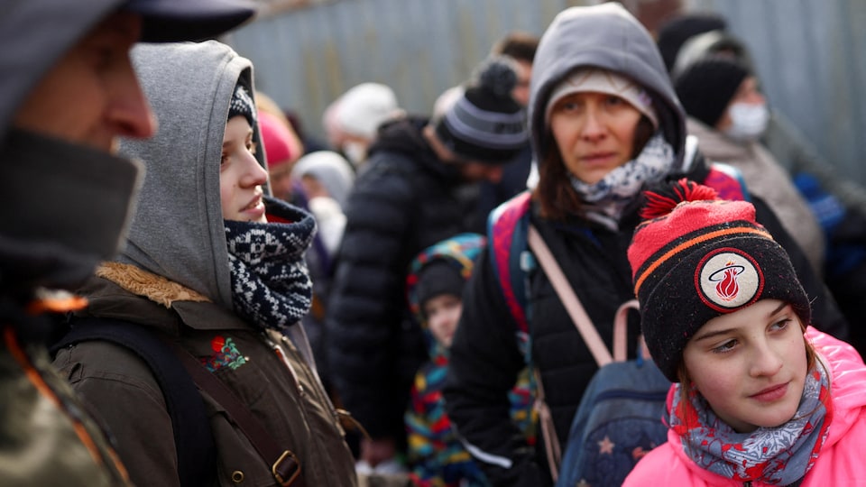 Une famille ukrainienne, fuyant l'invasion de l'Ukraine par la Russie, arrive au poste-frontière de Shehyni pour entrer en Pologne.
