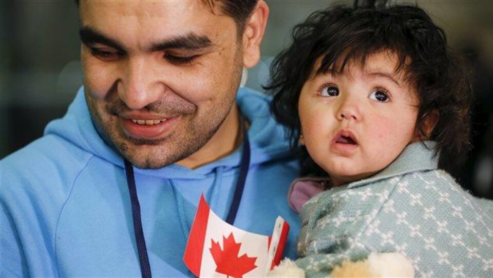 Un réfugié syrien et sa fille lors de leur arrivée à Toronto, en décembre 2015 .