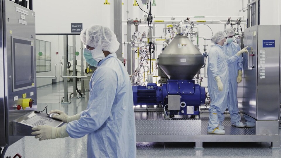 Des scientifiques de Regeneron Pharmaceuticals Inc. travaillent avec un bioréacteur dans un laboratoire.