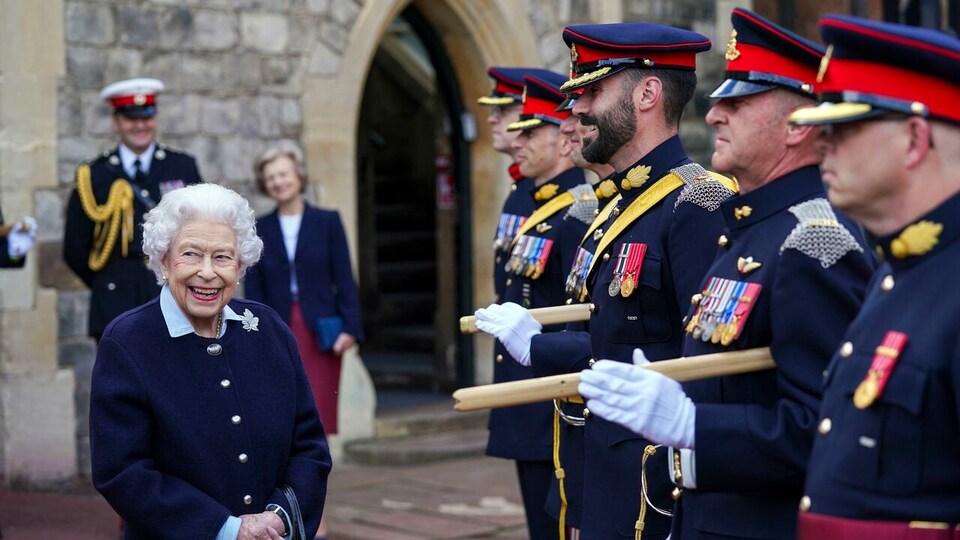 La reine Élisabeth II sourit avec des membres de l'armée canadienne.