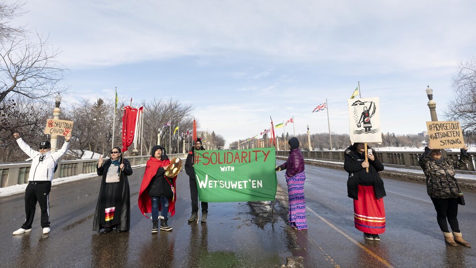 Des manifestants bloque le pont de la rue Albert à Regina en brandissant une banderole pour exprimer leur solidarité avec les Wet'suwet'en de la Colombie-Britannique.