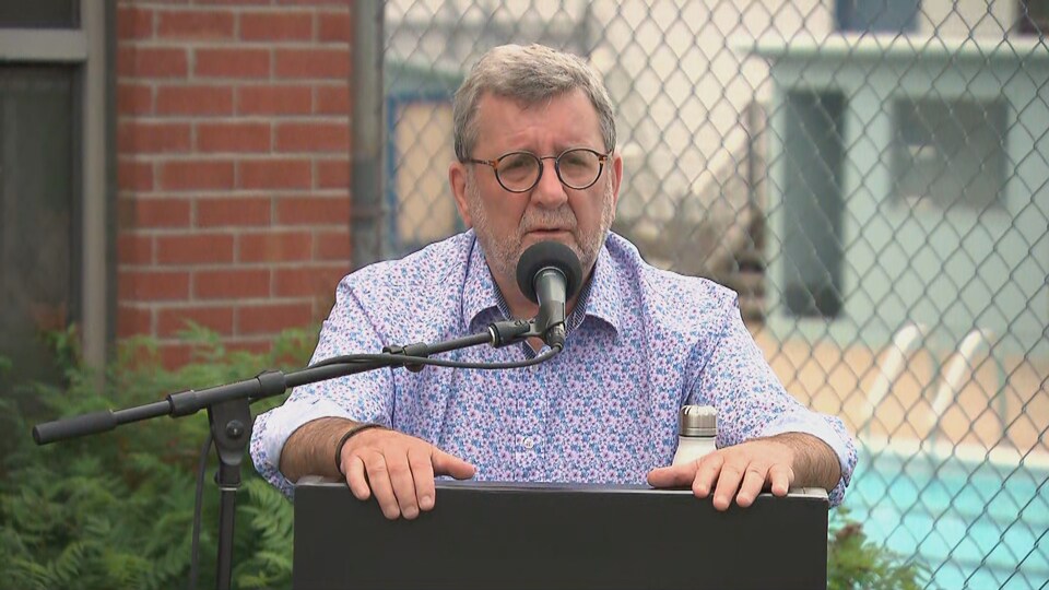 Régis Labeaume donne un point de presse à l'extérieur. Il se tient debout, derrière un lutrin.