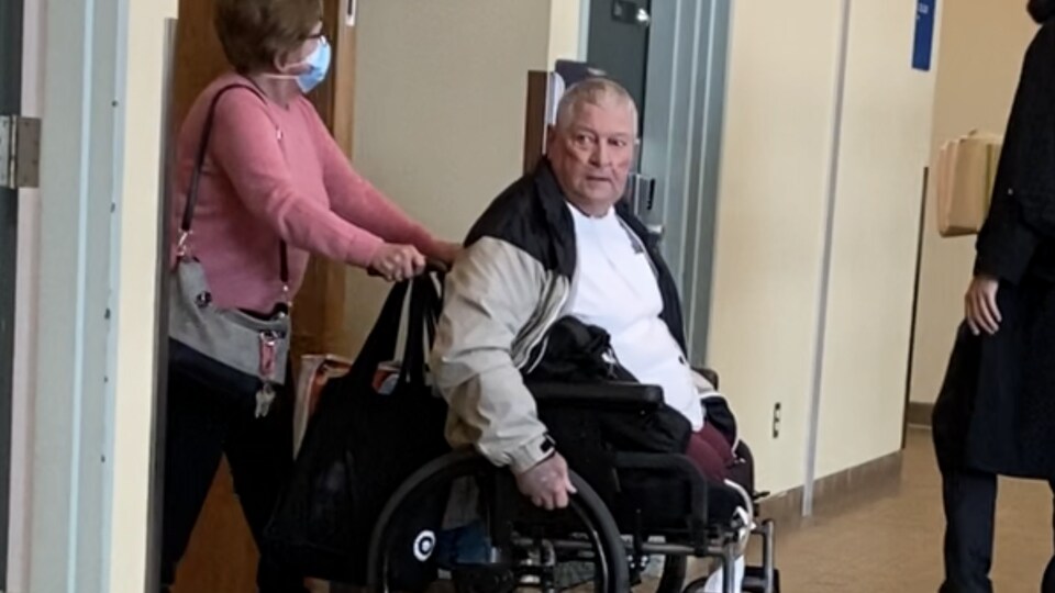L'homme qui se déplace en fauteuil roulant est poussé par sa conjointe.