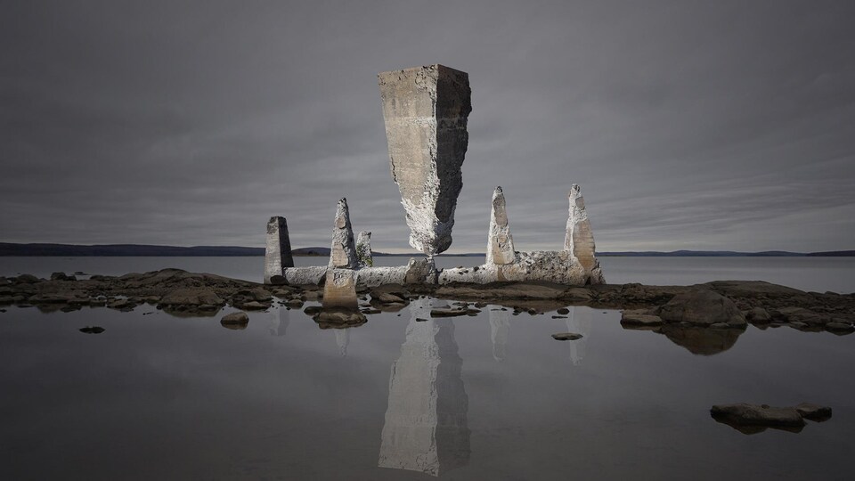 Photo d'une structure géante en roches sur une étendue d'eau.