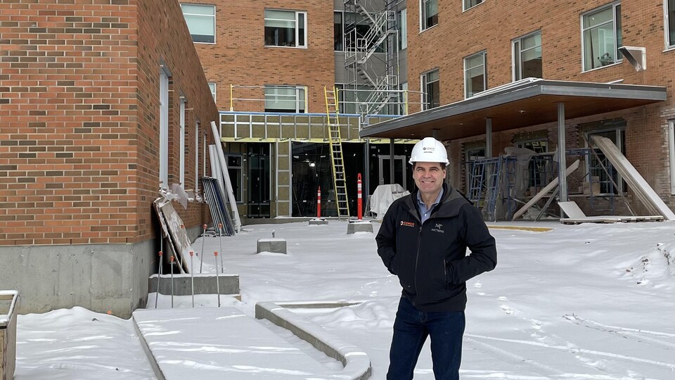 Un homme devant un chantier de construction dans un hôpital à Magog. 