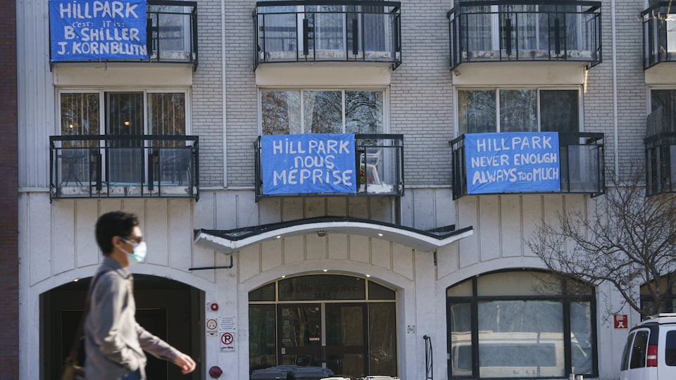 Des pancartes de contestation installées sur des balcons de logements d'un immeuble.