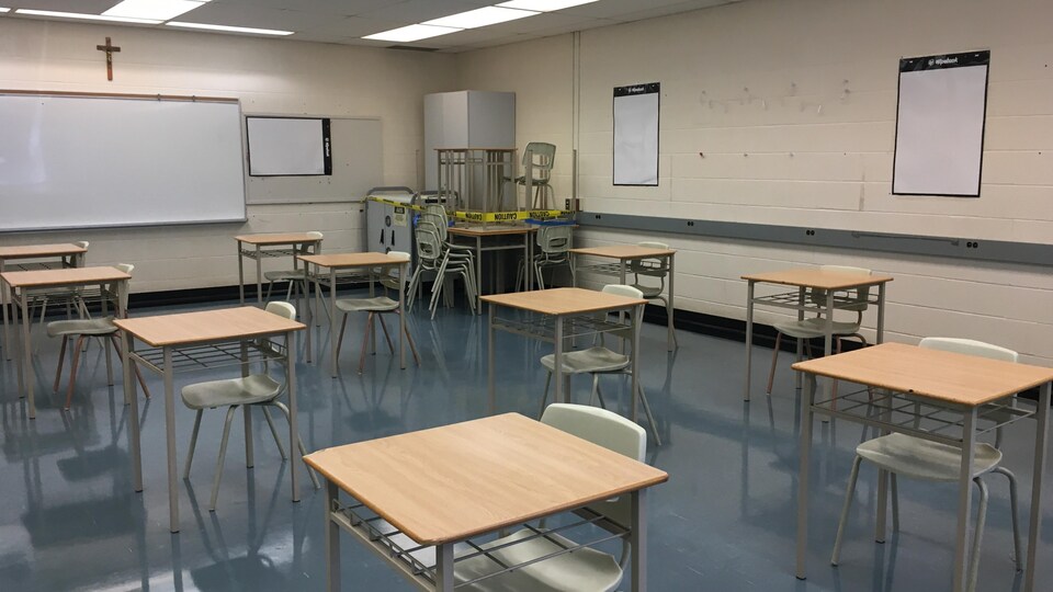 Une salle de classe avec des bureaux séparés par une bonne distance.