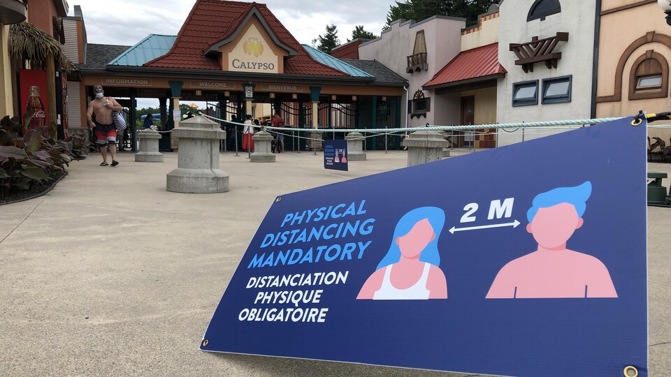 Un panneau indiquant de garder une distance de deux mètres à l'entrée d'un parc aquatique.