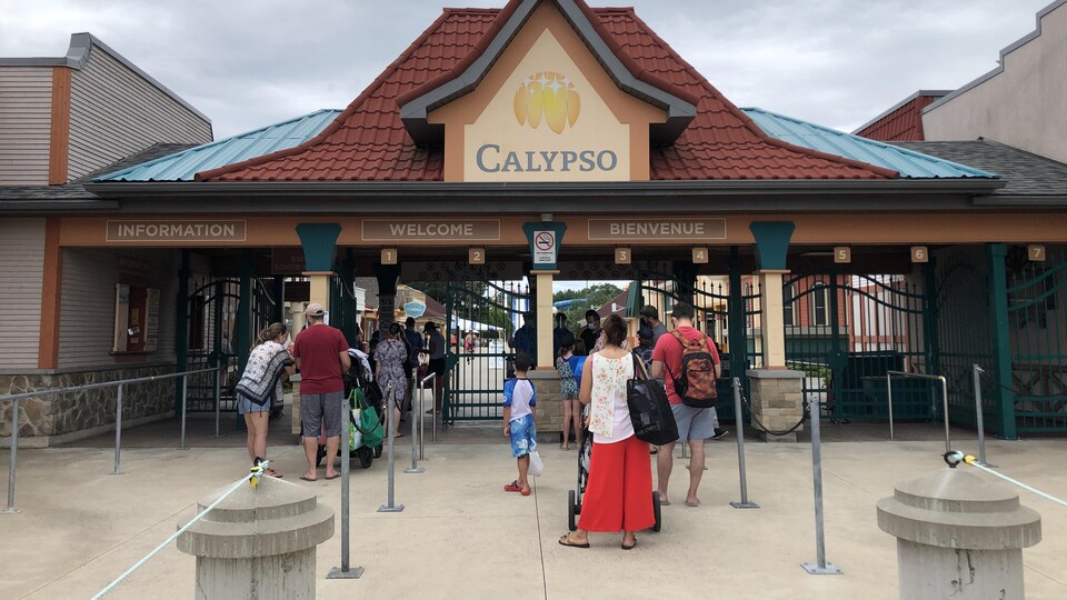 Des personnes attendent en file devant l'entrée d'un parc aquatique.