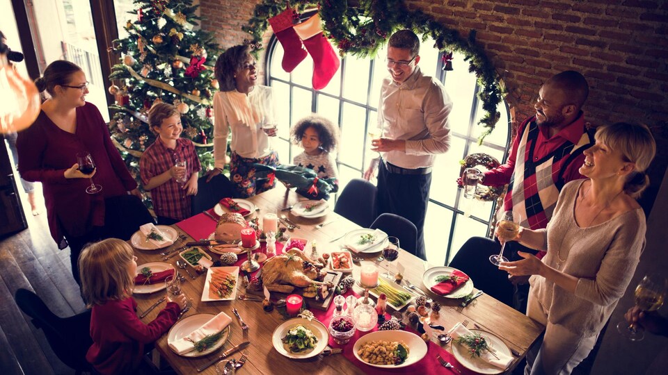 Plusieurs personnes sont réunis autour d'une table pour Noël.