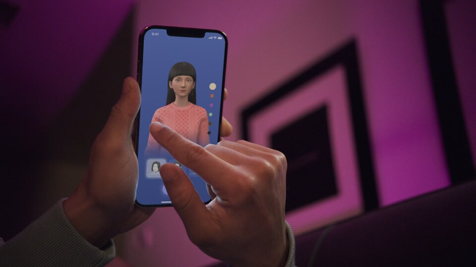 Une main touche un écran de téléphone affichant un avatar et des options de personnalisation. 