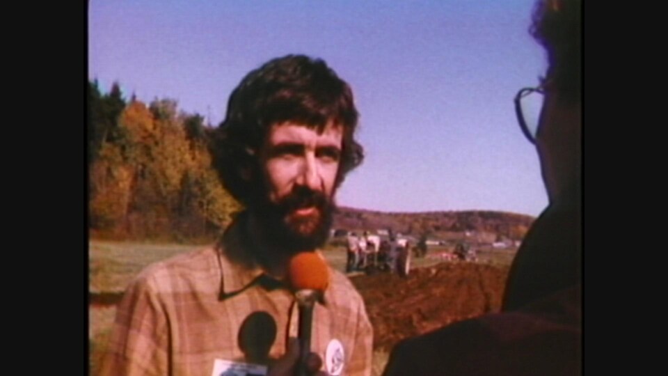 Image tirée d'un reportage de 1982 d'un homme qui parle au micro de Radio-Canada dans un champ.