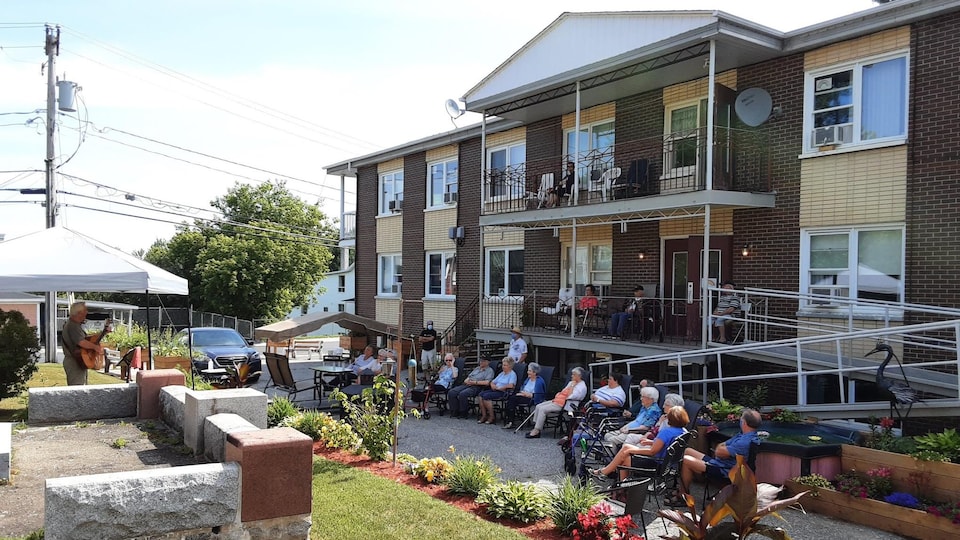 Des aînés assis derrière l'Auberge du Louis d'Or à Danville