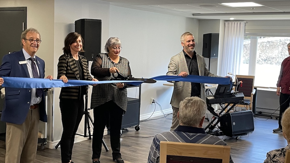 La mairesse de Rivière-du-Loup coupe le ruban inaugural, accompagnée de l'équipe de la Résidence des Bâtisseurs installée dans la ville.