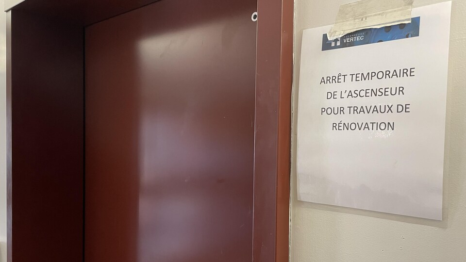 Une affiche collée près de l'ascenseur qui mentionne un arrêt temporaire pour travaux de rénovation.