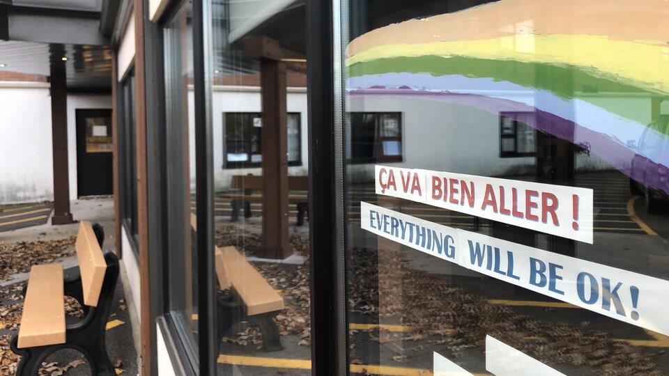 Un arc-en-ciel peint sur la fenêtre de la résidence avec l'expression "ça va bien aller!".