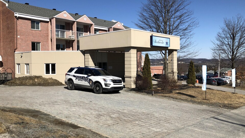 Le devant de la résidence avec une voiture de police.