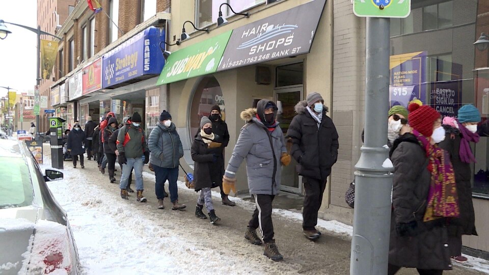 Des gens marchent sur le trottoir au centre-ville d'Ottawa.