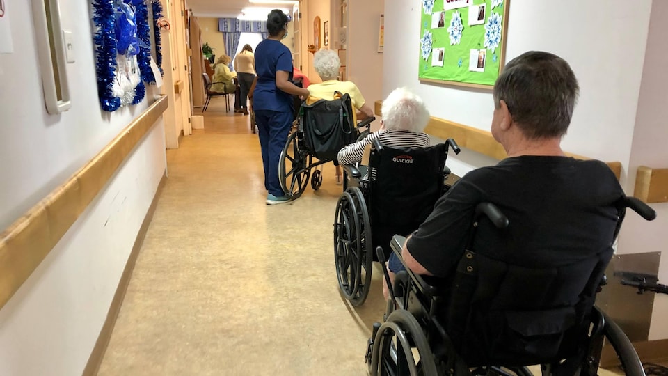 Des résidents d'un centre de soins de longue durée attendent dans leur fauteuil roulant.