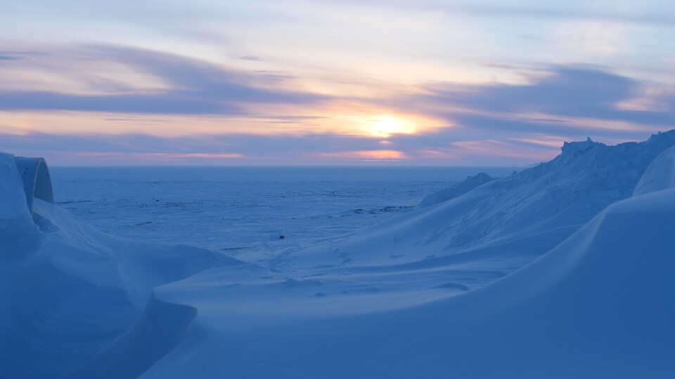 Le soleil de couche derrière l'étendue gelée. 