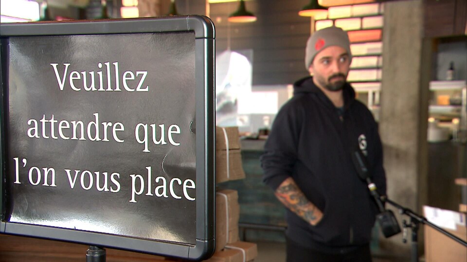 Une affiche sur laquelle il est écrit : Veuillez attendre que l'on vous place.