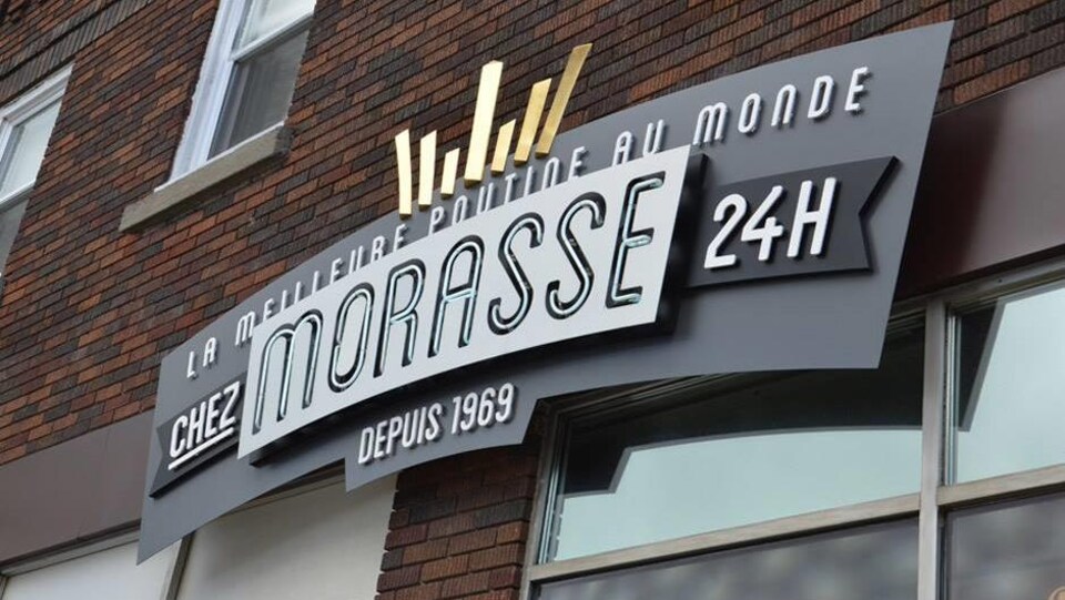 Une enseigne de casse-croûte indique «Chez Morasse, 24h, depuis 1969, la meilleure poutine au monde».