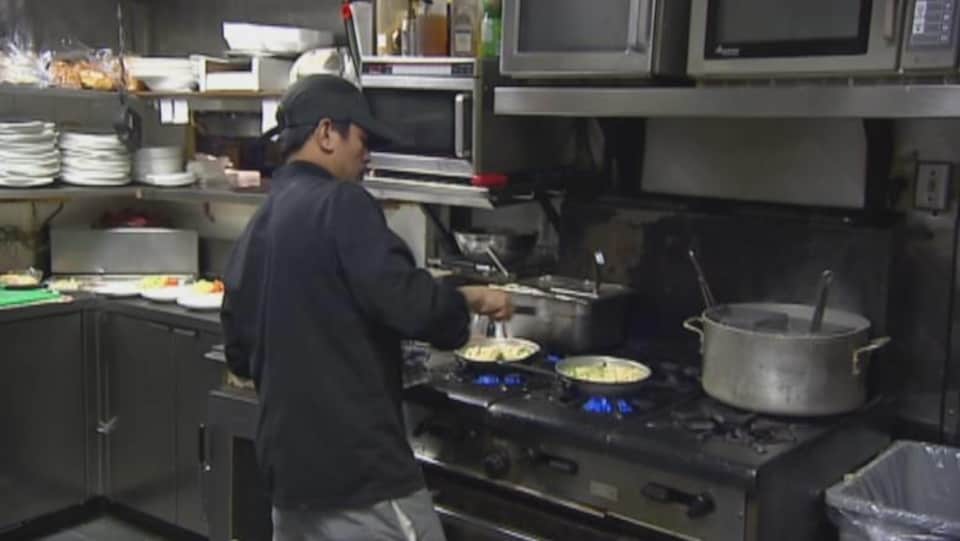 Un cuisinier prépare des plats dans un restaurant
