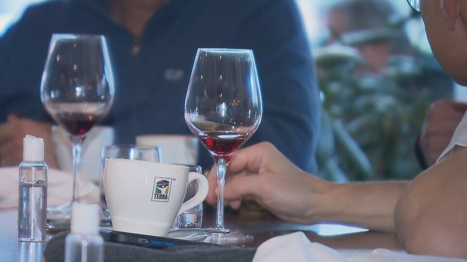 Deux verres de vin et de la vaisselle sur une table de restaurant.