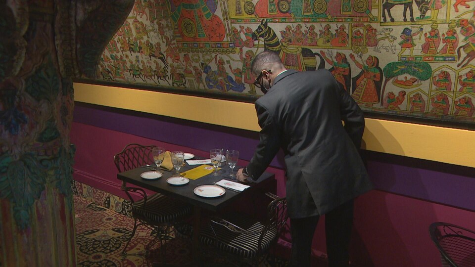 Un serveur met la table dans un restaurant.