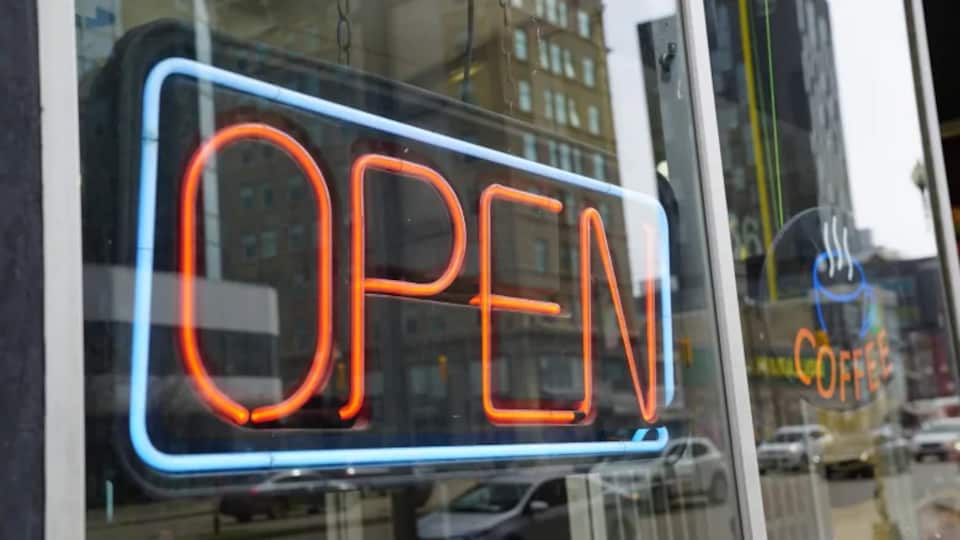 Un inscription au néon qui dit ouvert dans la vitrine d'un commerce.