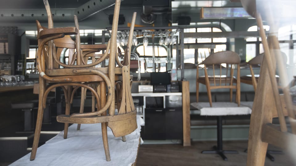 Des chaises placées sur des tables d'un restaurant désert.