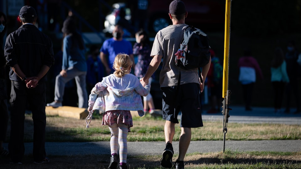 Un parent et un enfant marche main dans la main. 
