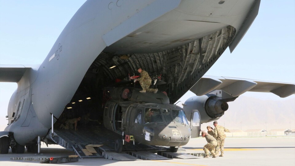  Des soldats chargent un hélicoptère UH-60L Blackhawk dans un C-17 Globemaster III de l'armée de l'air américaine pendant le retrait des forces américaines en Afghanistan, en juin 2021.