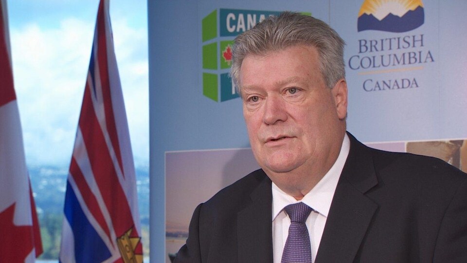 Le ministre de l'Énergie, des Mines et du Gaz naturel, Rich Coleman, en costume lors d'un point de presse