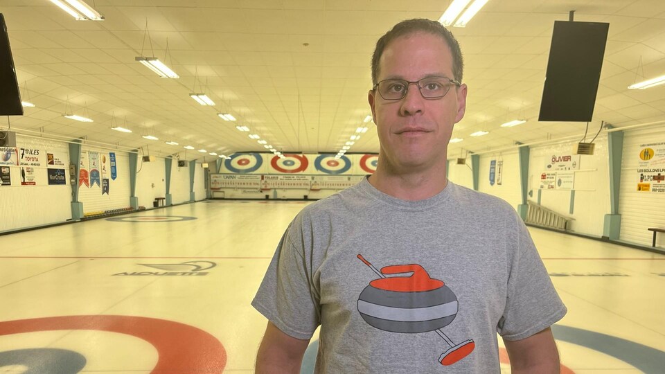 Le vice-président du club de curling de Sept-Îles, Richard Jauron, souriant devant les glaces de curling.