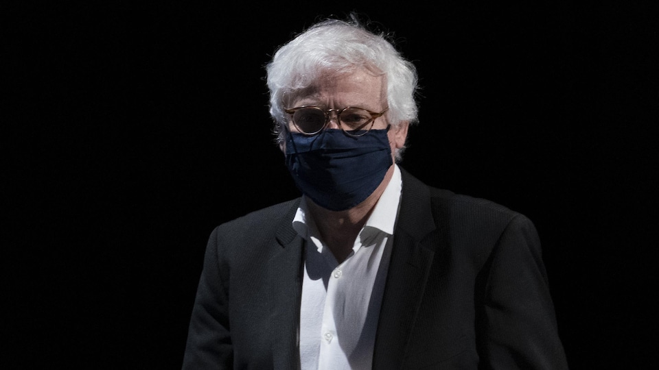 Le Dr Richard Massé, debout devant un fond noir.