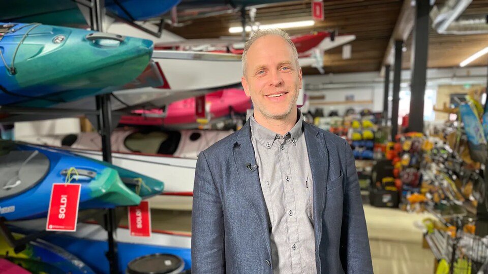 Rick Shone devant des kayaks dans son magasin.