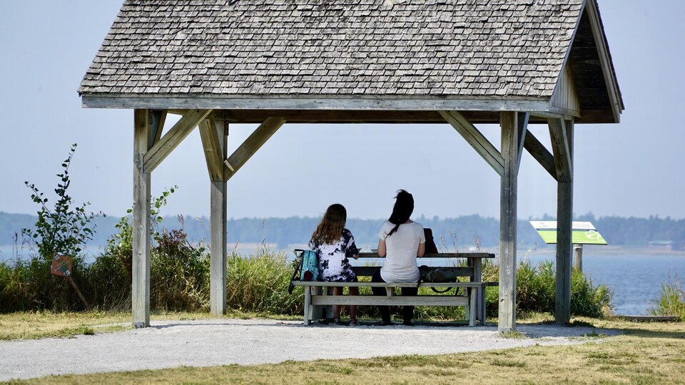Deux personnes regardent le fleuve.