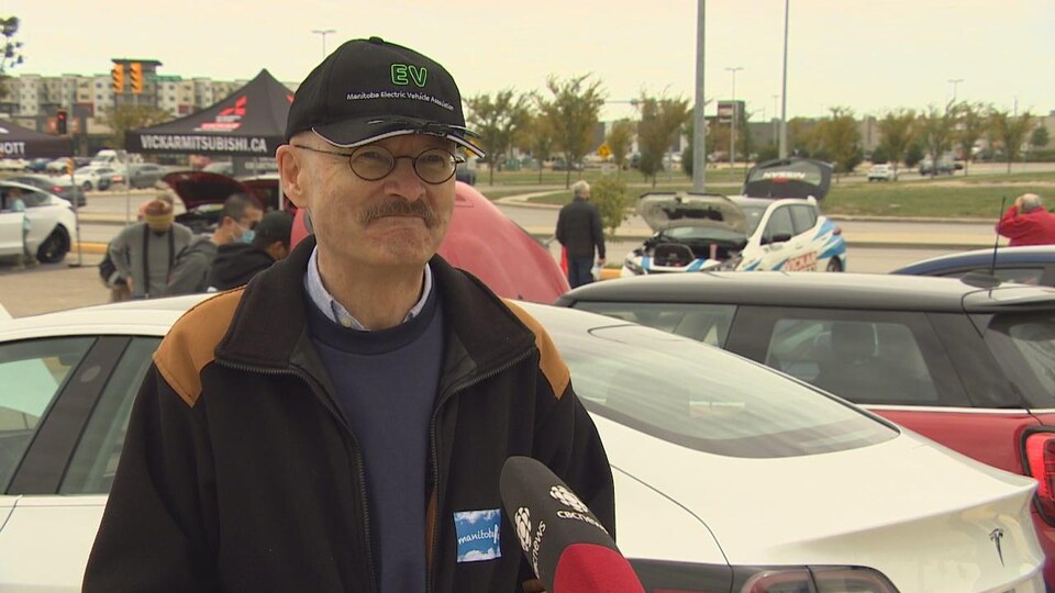 Robert Elms est dans un stationnement, entouré de voitures.
