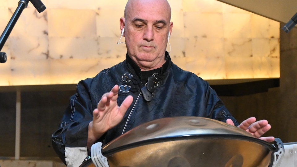 Robert Len joue un instrument à percussion, le handpan.