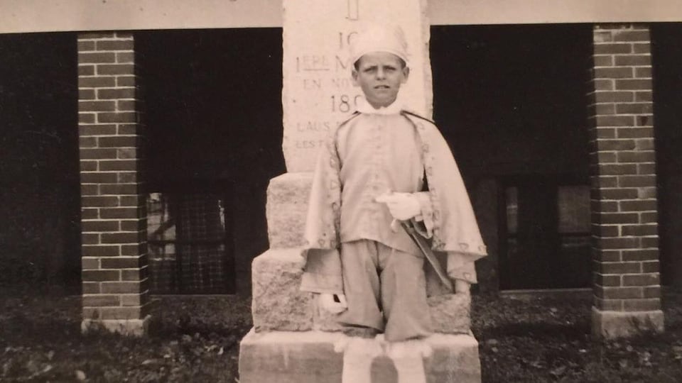 Robert Lupien, enfant, devant son école qui deviendra plus tard une résidence pour aînés où il ira passer ses vieux jours.